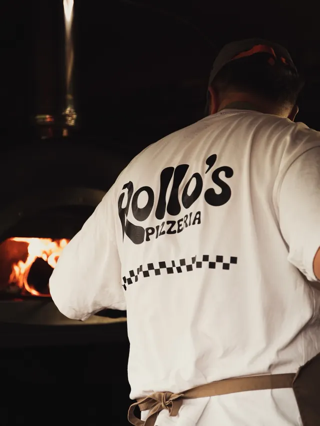 Cooking at the oven in a Rollo's t-shirt