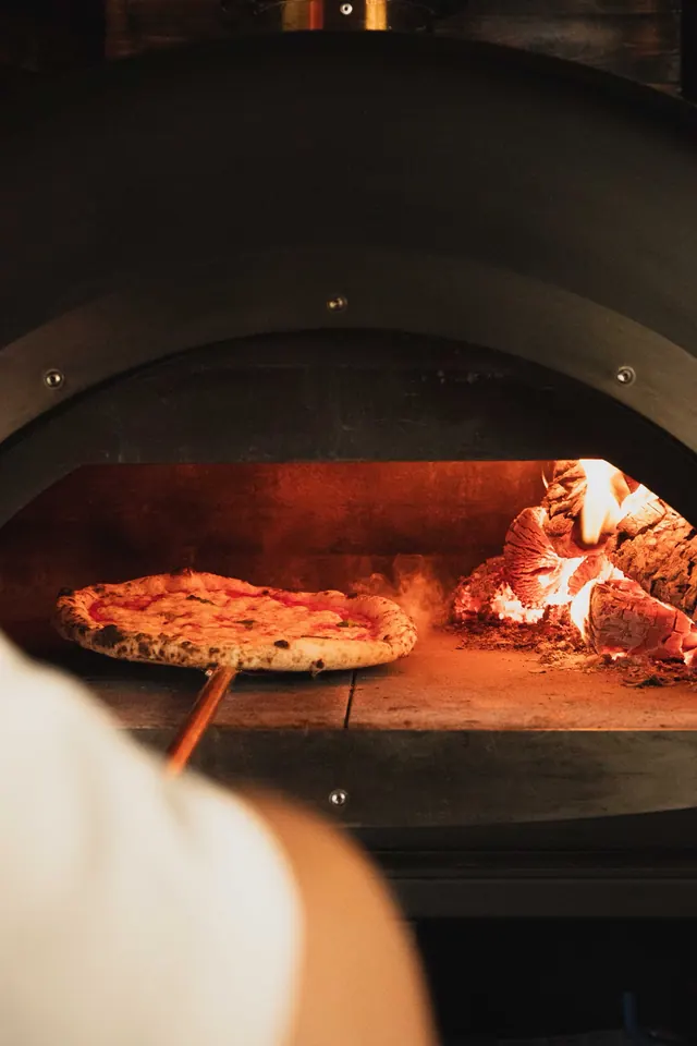 A pizza cooking next to the fire in our oven