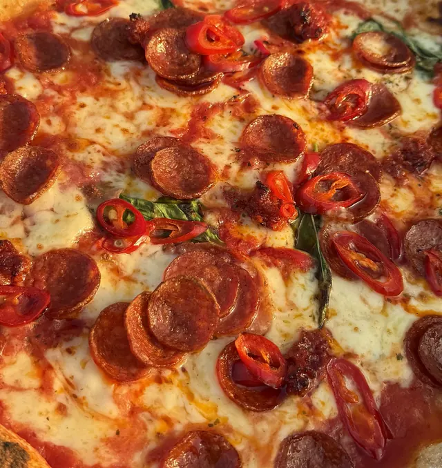 Close-up of pepperoni and fresh chilli